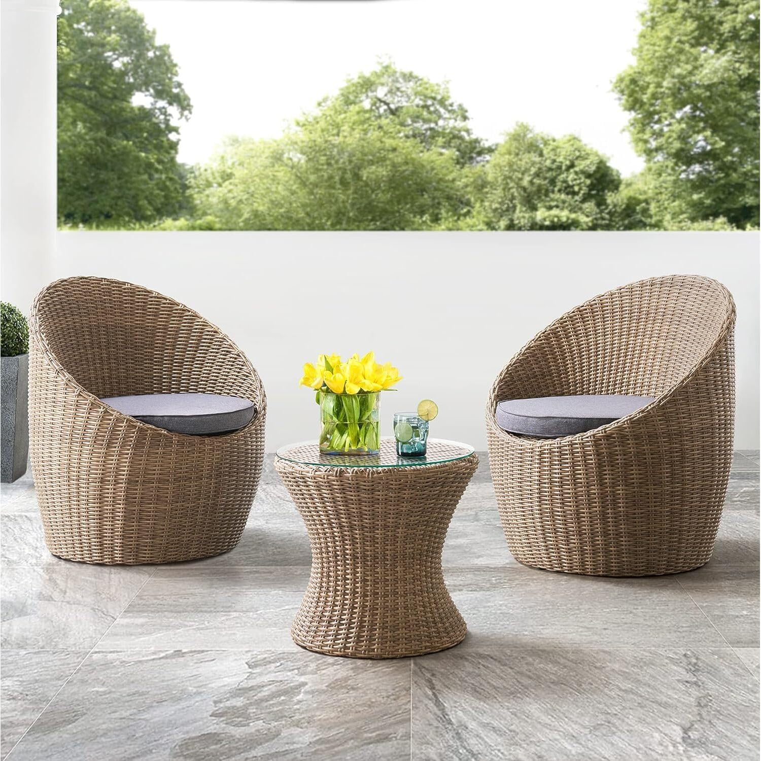 two round outdoor chairs woven from wicker with a round side table