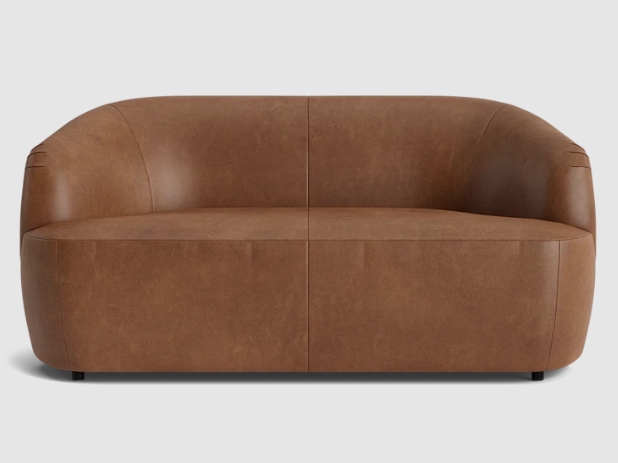 Brown leather upholstered curved sofa