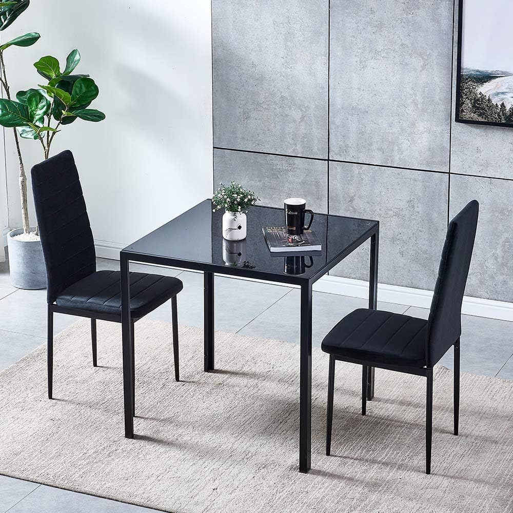 Smoky glass dining table with two velvet-upholstered chairs