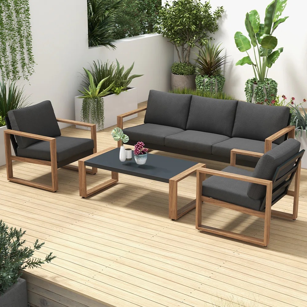 dark grey and wood outdoor patio furniture set made with wooden framing and charcoal cushions three seat sofa with weather proof armchairs and coffee table