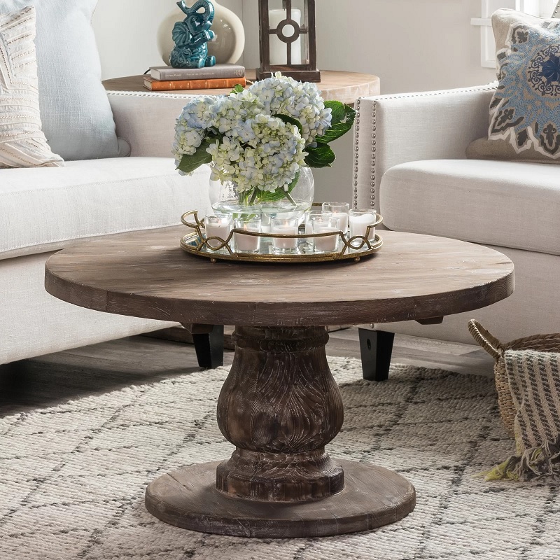 classic traditional farmhouse round coffee table with thick turned pedestal base made from reclaimed wood with a distressed finish vintage looking living room farmhouse furniture