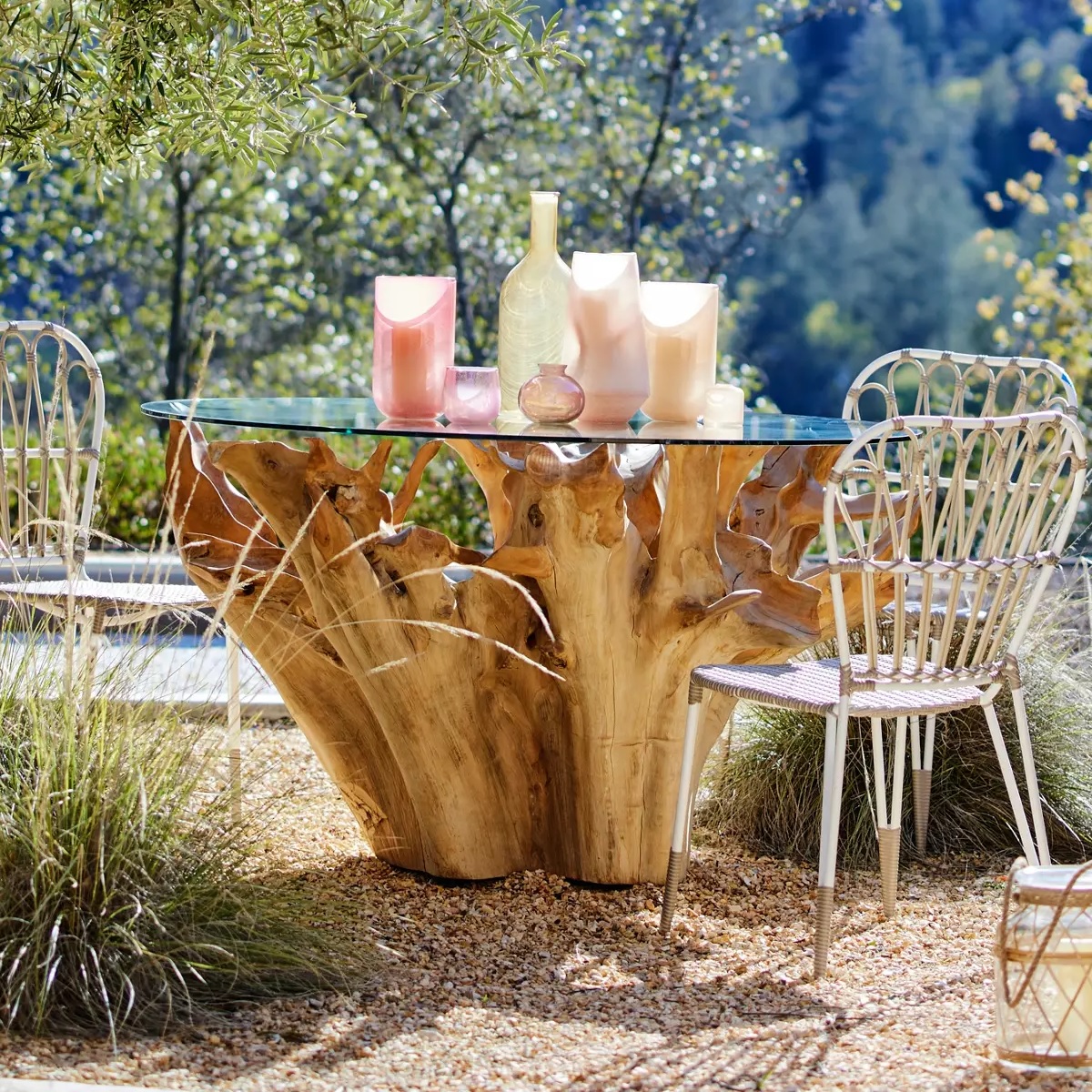 outdoor dining table made from a large natural teak root with glass top