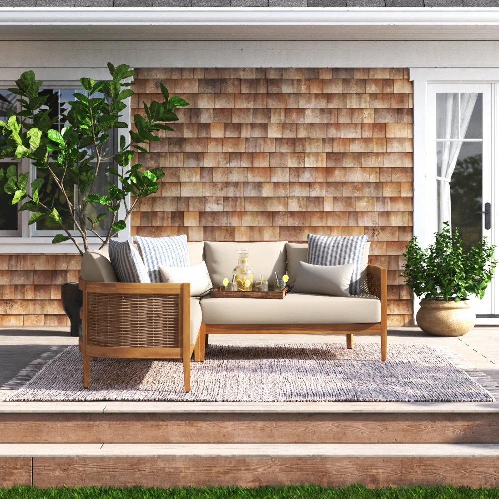 wood sofa with rounded edges, wicker sides, and beige cushions