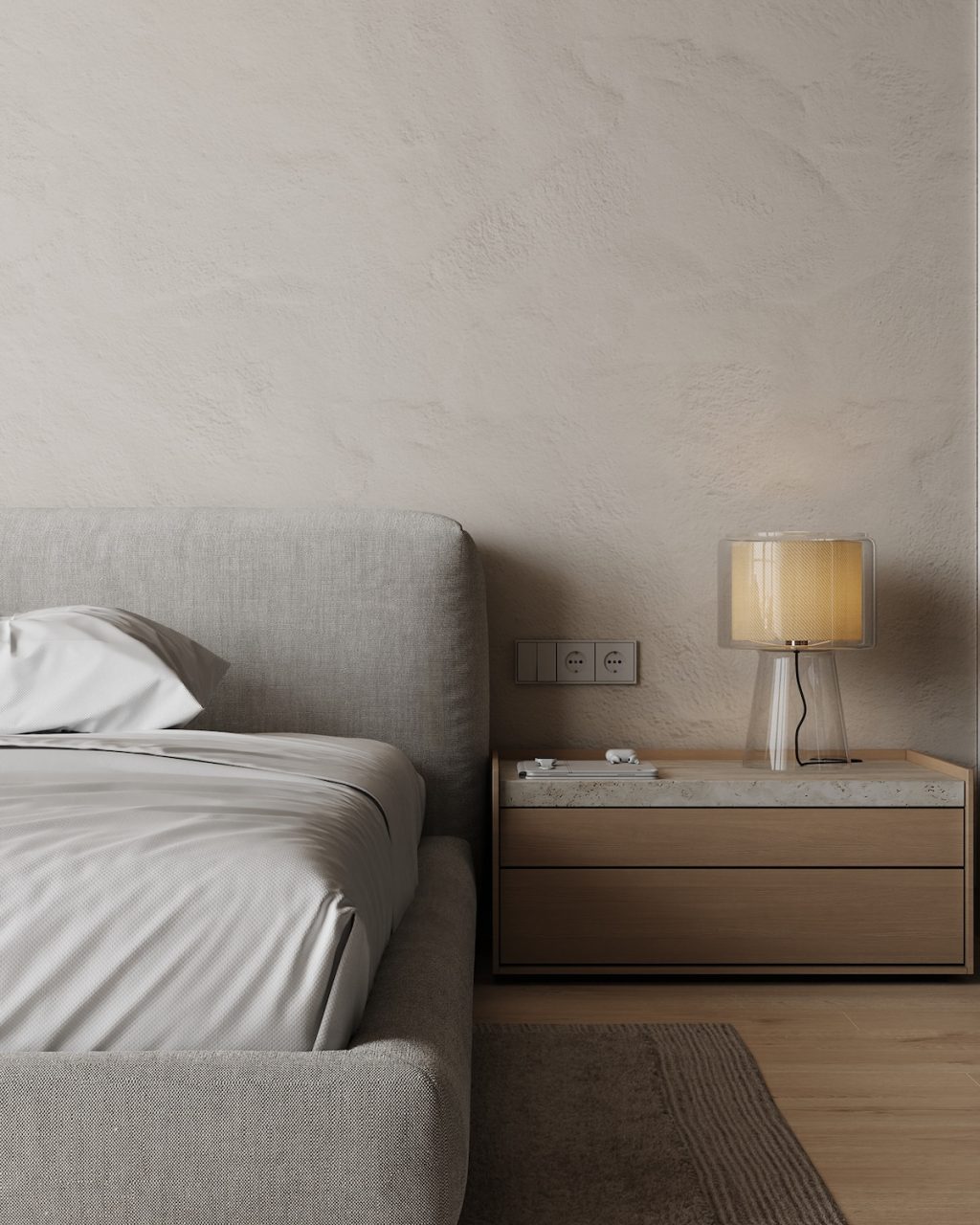 clear lamp on beige sidetable with bed