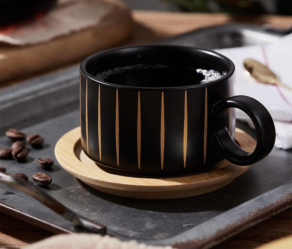 Gold and black cappuccino cup on a wooden saucer