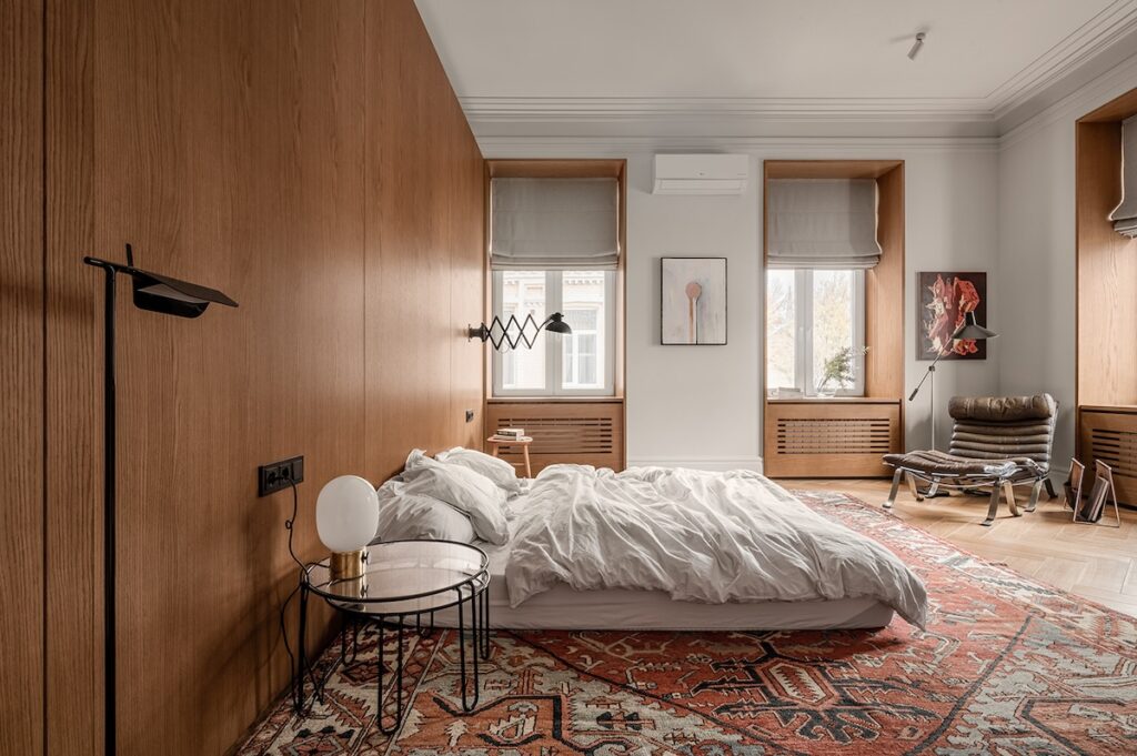 bedroom with wooden wall and colorful rug