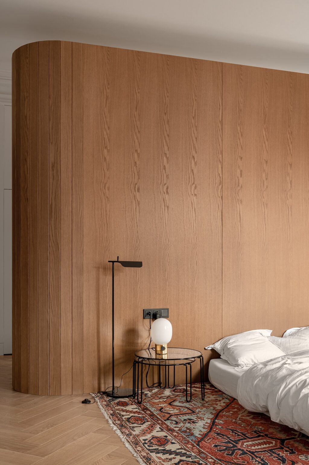 curved oak wall with modern bedside setup