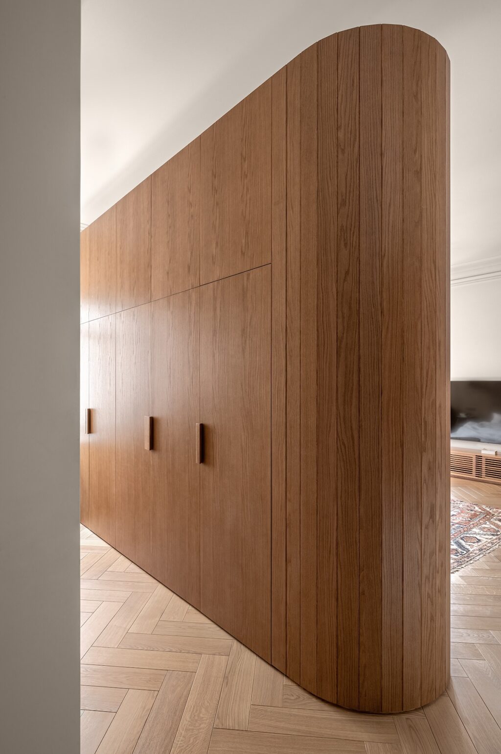 curved oak wardrobe in serene bedroom