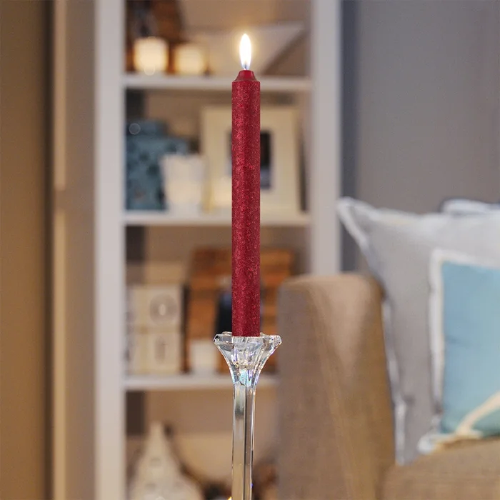 red taper candle in transparent holder